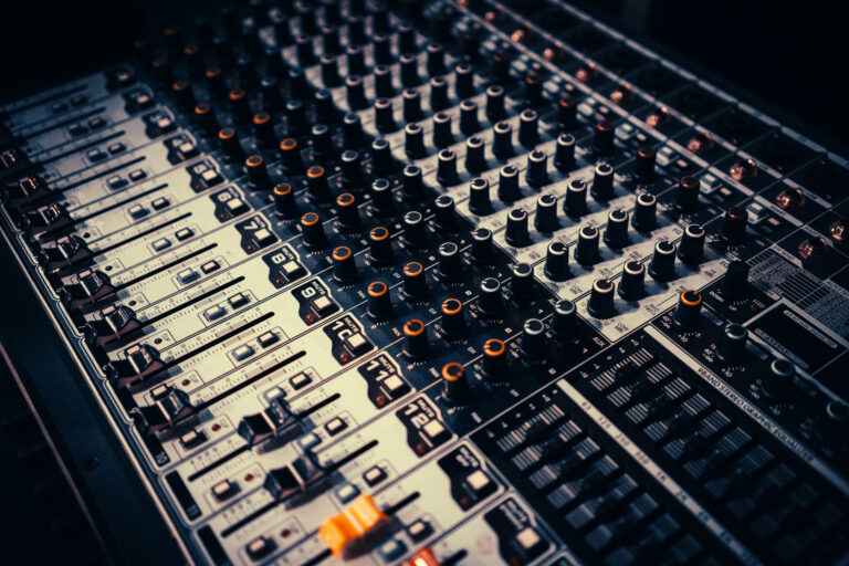 Faders et potentiomètres alignés sur une console de mixage