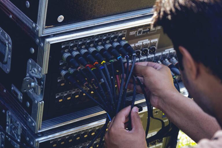 Technicien branchant un câble sur un équipement audio de studio