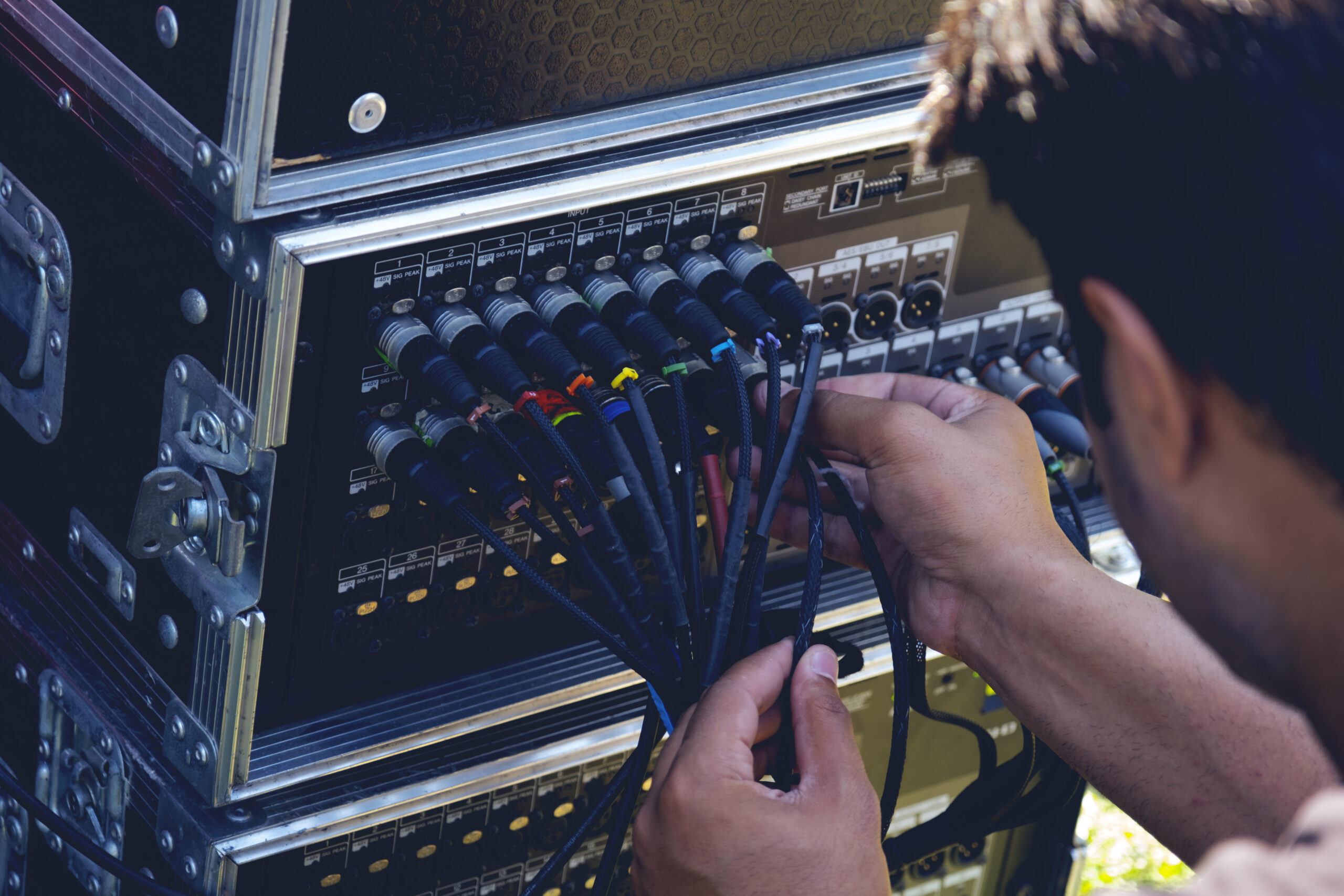 Technicien branchant un câble sur un équipement audio de studio