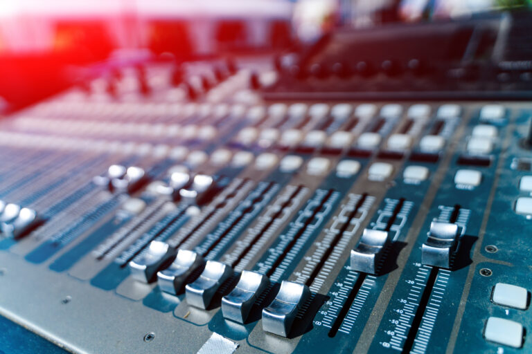 Faders et potentiomètres alignés sur une table de mixage
