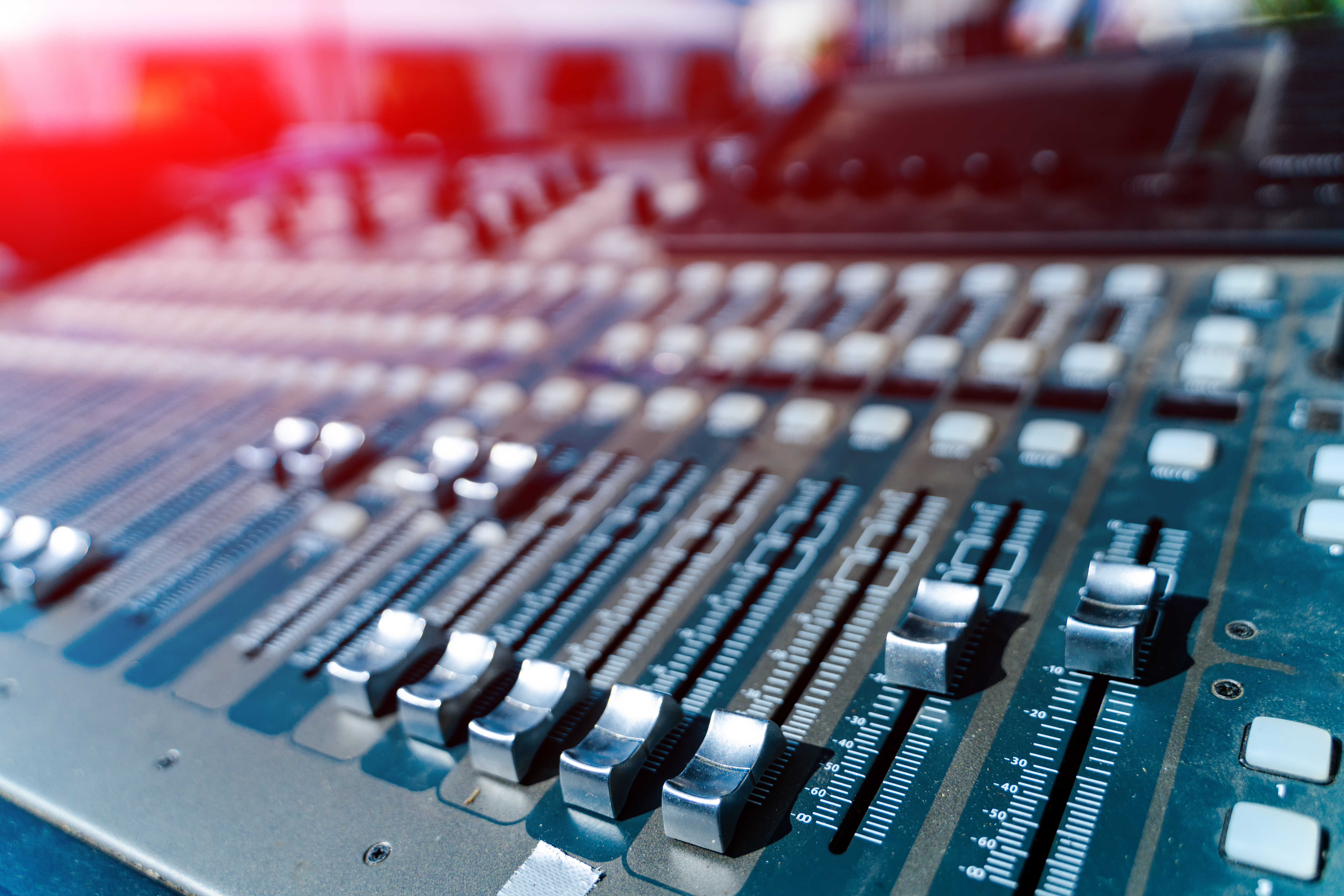 Faders et potentiomètres alignés sur une table de mixage