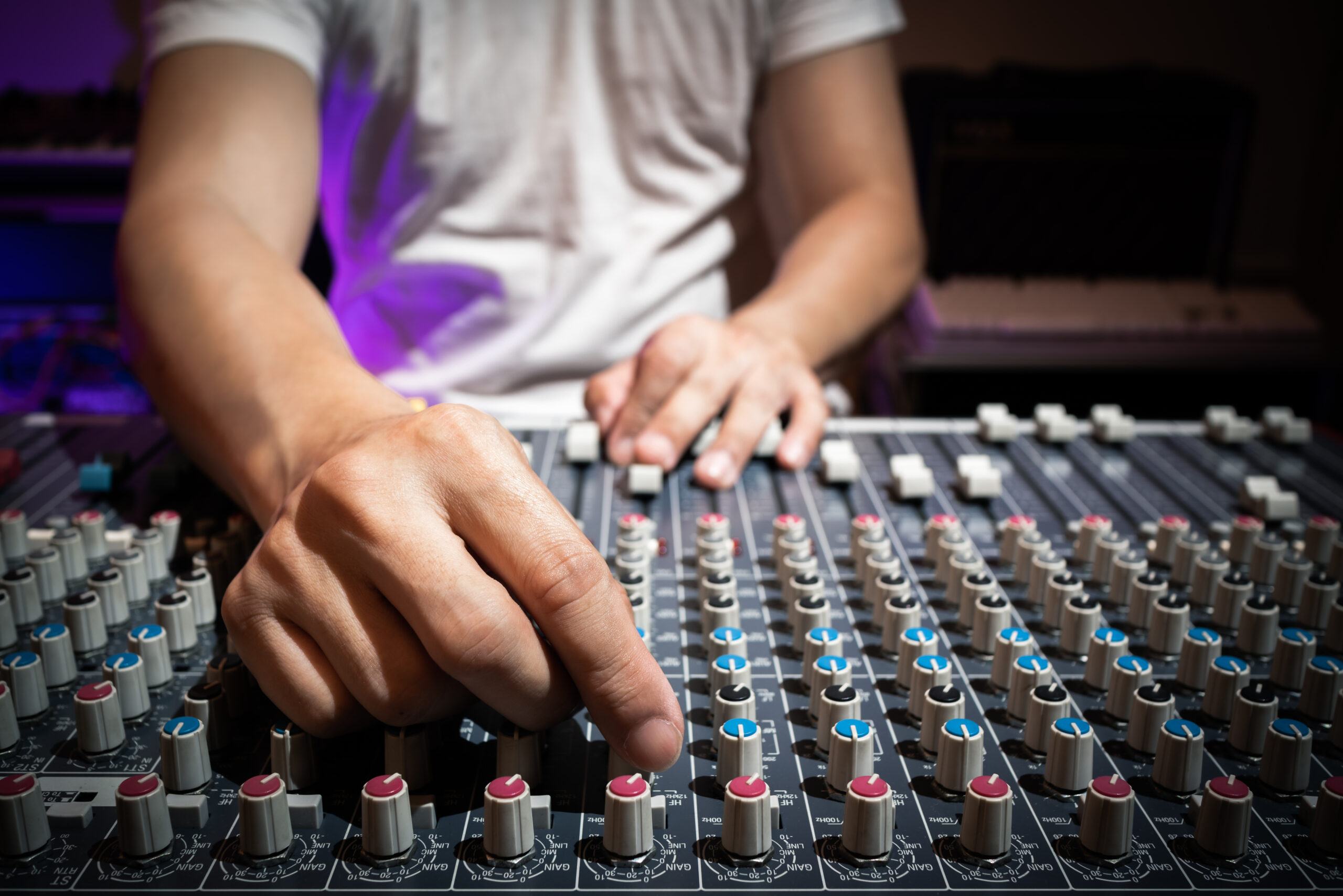 Main réglant l’égalisation sur une console de mixage