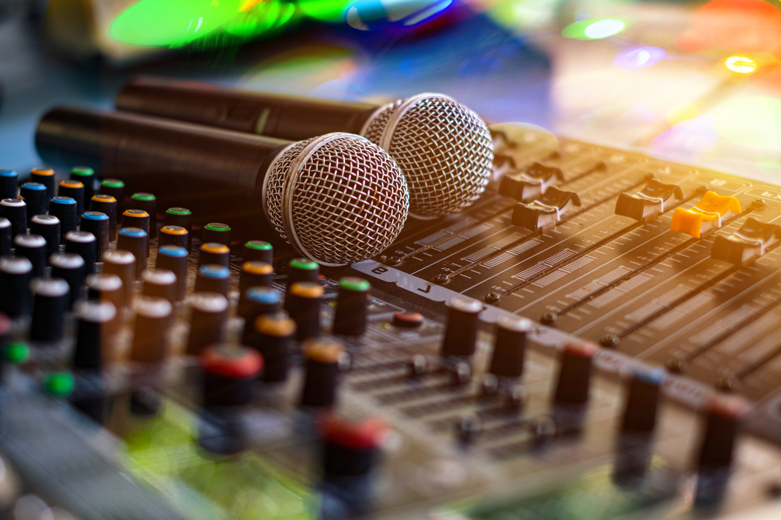 Microphone posé devant les commandes d’une table de mixage