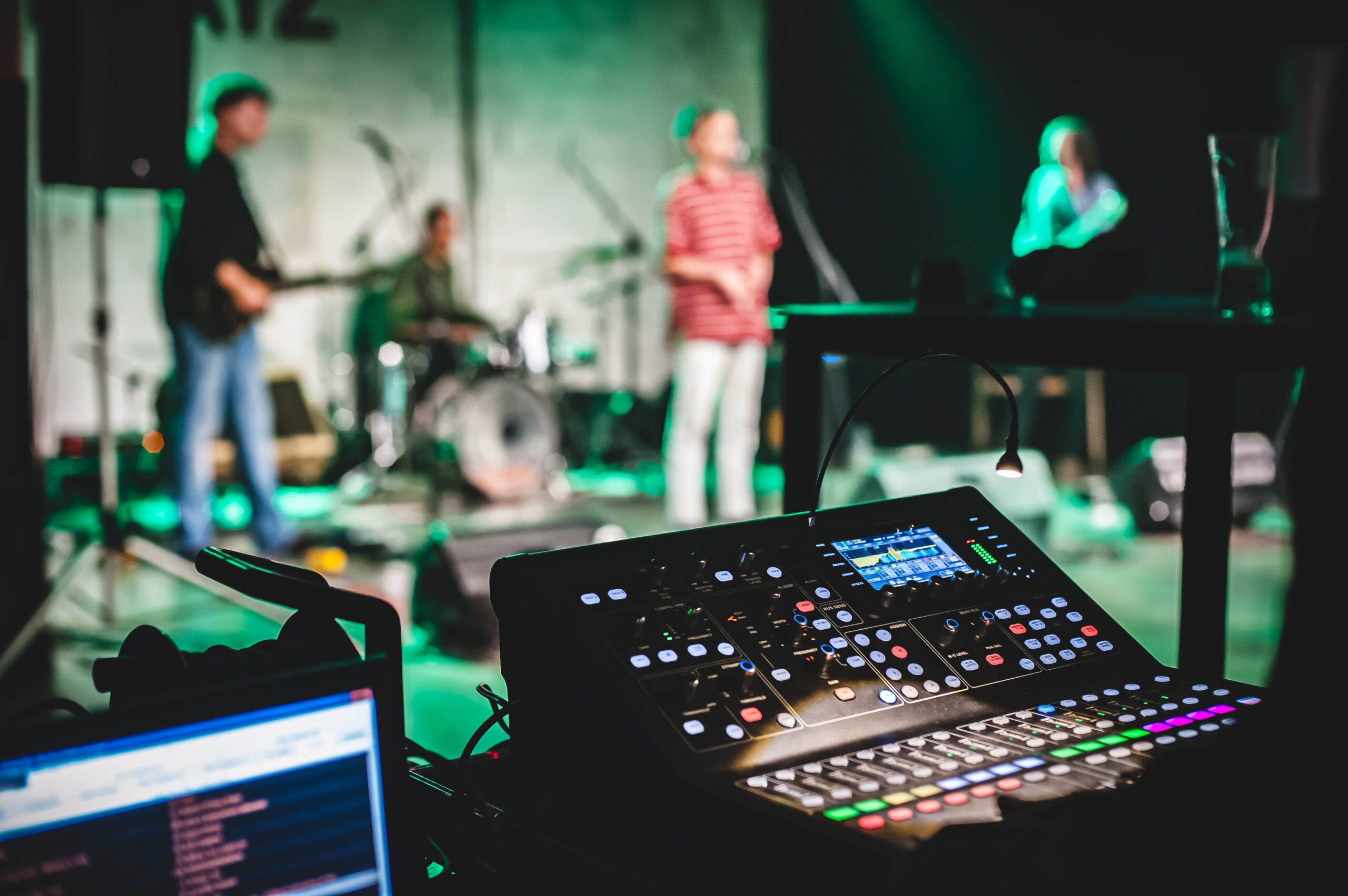 Table de mixage installée devant un groupe en répétition
