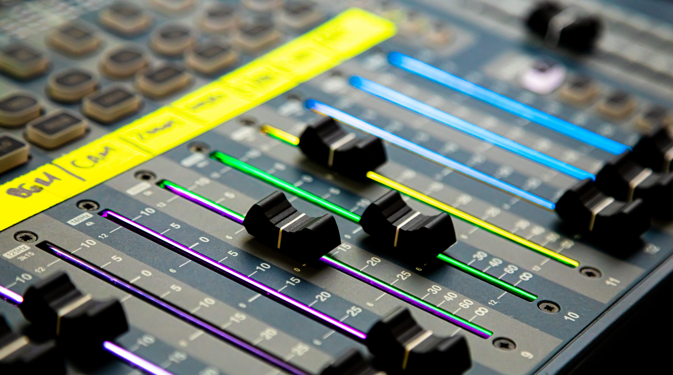 Faders et potentiomètres éclairés sur une table de mixage